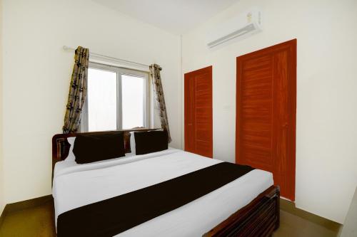 a bedroom with a large bed with a window at Super Collection O DLF CyberCity Hyderabad Formerly Key Suites in Kondapur