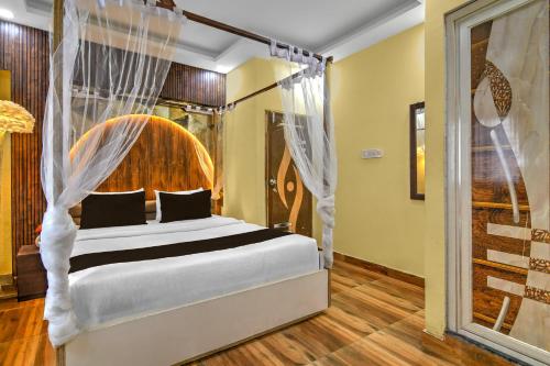 a bedroom with a bed with a canopy at Hotel O Bangur Kolkata Formerly The Avenue Inn in Nager Bazaar