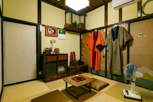 a room with a room with a fan and a table at はやちねの宿ラビット in Hanamaki