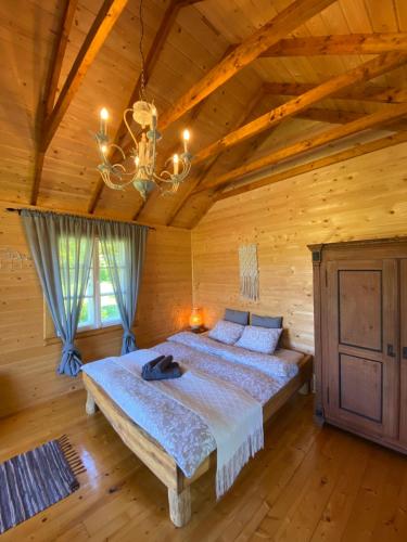 a bedroom with a bed in a log cabin at Cozy chalet for nature lovers in Ķevele