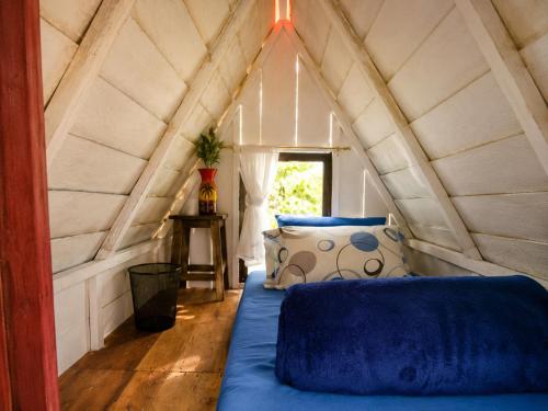 a room with a bed and a window in a attic at Ecohotel El Amarradero in Alejandría