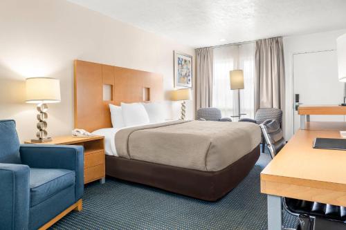 a hotel room with a bed and two chairs at Quality Inn Rock Springs - Green River in Rock Springs