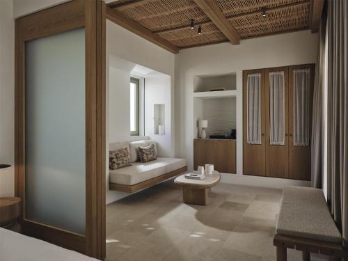 a room with a bed and a couch and a table at Parian Chronicle Hotel Paros, Destination by Hyatt in Kampos Paros