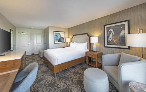 a hotel room with a bed and a living room at Redondo Beach Hotel, Tapestry Collection by Hilton in Redondo Beach
