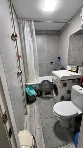 a small bathroom with a toilet and a sink at Квартира посуточно in Balqash
