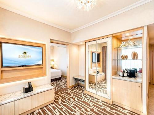 a hotel room with a television and a bedroom at 澳門維景酒店 in Macau