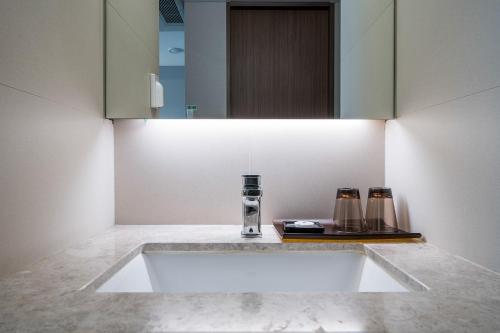 a bathroom with a sink and a mirror at Busan Business Hotel in Busan