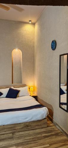 a bedroom with a large bed and a mirror at Omani Guest House نزل البيت العماني in Nizwa