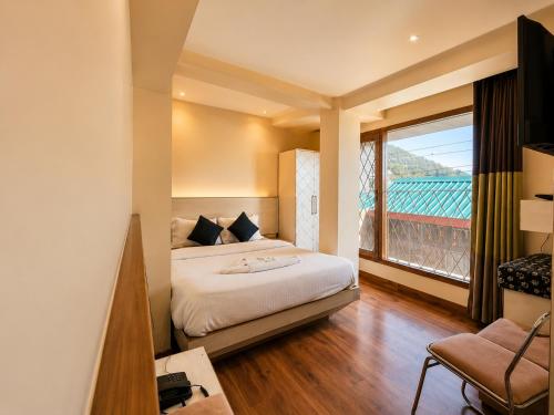 a hotel room with a bed and a large window at The Town Boho in Shimla
