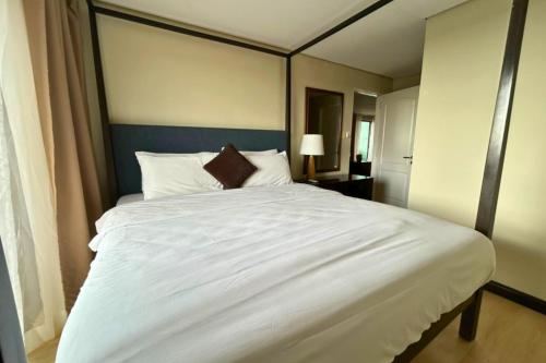 a bedroom with a large white bed with a canopy at Crosswinds Swiss Deluxe Suite in Tagaytay