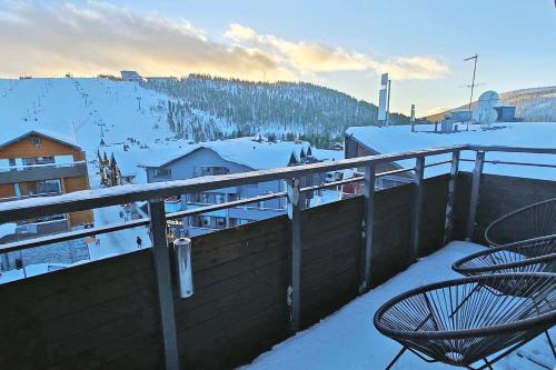a balcony with two chairs in the snow at Hotel Hullu Poro in Levi