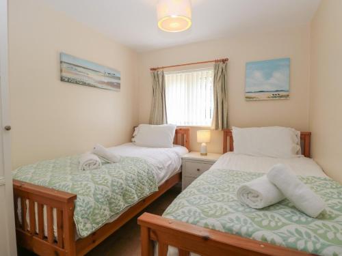 a bedroom with two beds and a window at 14 The Dell in Norwich