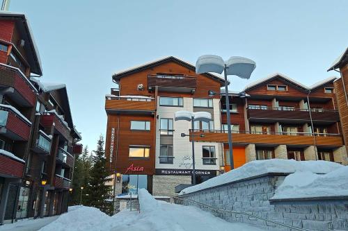 a snow covered street in front of a building at Hotel Hullu Poro in Levi