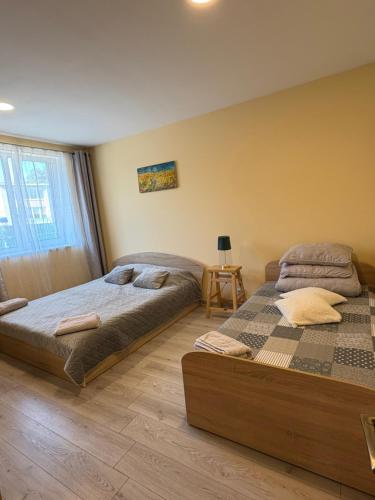 a bedroom with two beds and a table at Butas pačiame miesto centre in Telšiai
