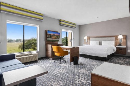 a hotel room with a bed and a desk and a couch at Hampton Inn & Suites Houston Rosenberg in Rosenberg