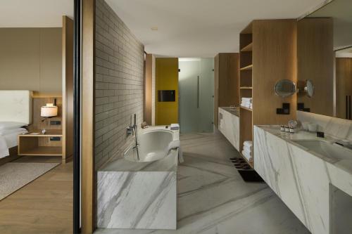 a bathroom with two sinks and a bath tub at Andaz Delhi, by Hyatt in New Delhi