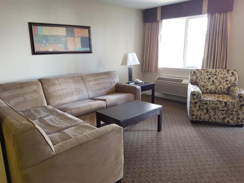 a living room with a couch and a chair at Travelodge by Wyndham Kamloops Mountview in Kamloops