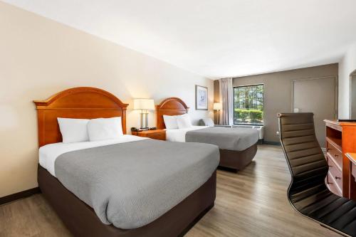 a hotel room with two beds and a television at Quality Inn Battleboro - Rocky Mount in Battleboro