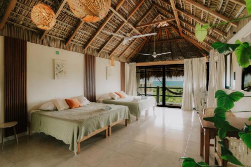 a bedroom with two beds in a room with windows at Montero Residences in Brisas de Zicatela