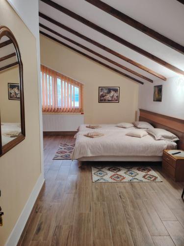 a bedroom with a large bed and a mirror at Casa Alma in Paşcani