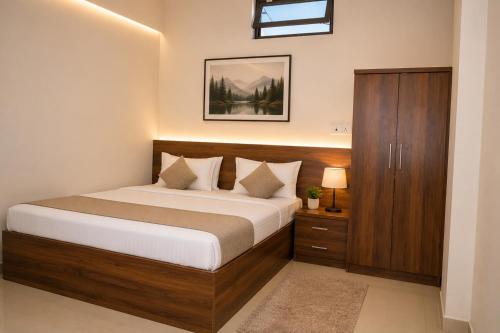 a bedroom with a bed and a wooden cabinet at Hotel Jayaditya Palace in Ayodhya