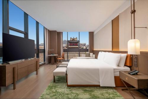 a hotel room with a bed and a flat screen tv at Wyndham Garden Datong Ancient City in Datong