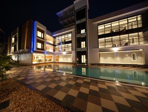 a building with a swimming pool at night at Hanric by Eight Continents Amaranta, Varkala in Varkala