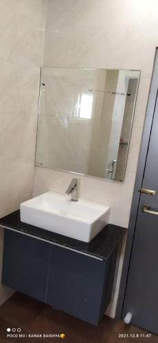 a bathroom with a white sink and a mirror at Hotel Asian Palace in Guwahati