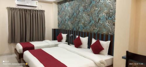 a bedroom with two beds and a painting on the wall at Hotel Asian Palace in Guwahati