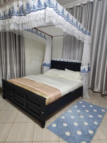a bedroom with a canopy bed and a rug at Rippon Nest in Jinja