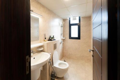 a small bathroom with a toilet and a sink at Beige Apartment by Bait Zain - Bousher in Muscat