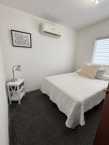 a bedroom with a bed and a air conditioner at Casa en grupo, terraza y alberca compartida in Mexicali