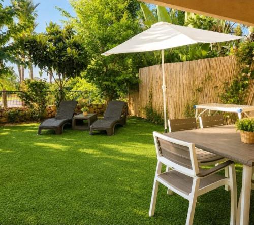 a patio with a table and chairs and an umbrella at סי מיה - דירות יוקרתיות במתחם נאות גולף in Caesarea
