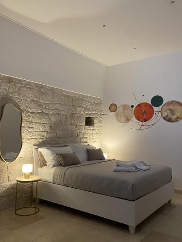 a bedroom with a bed and a stone wall at Vénere maison de charme in Giovinazzo