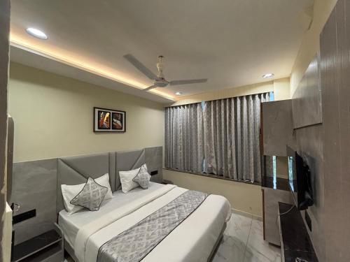 a bedroom with a large bed and a window at Hotel Planet Town in Ahmedabad