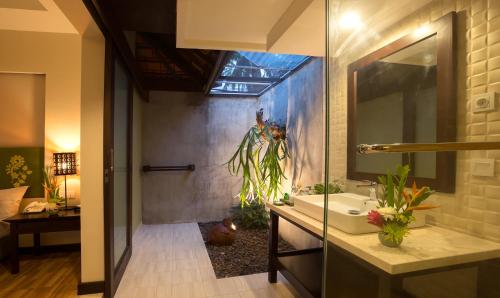 a bathroom with a sink and a mirror at Ketapang Indah Hotel in Banyuwangi