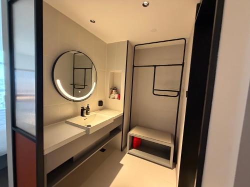 a bathroom with a sink and a mirror at Ibis Haiyan Economic Development Zone in Haiyan