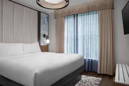 a bedroom with a bed and a large window at Embassy Suites by Hilton Birmingham Hoover in Birmingham