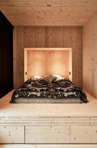 a bed in a room with a wooden wall at Meteorite House in Kontiolahti