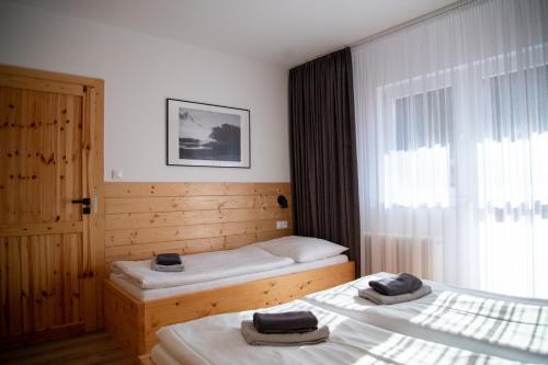 a bedroom with two beds and a window at Penzion Sabina in Vernár