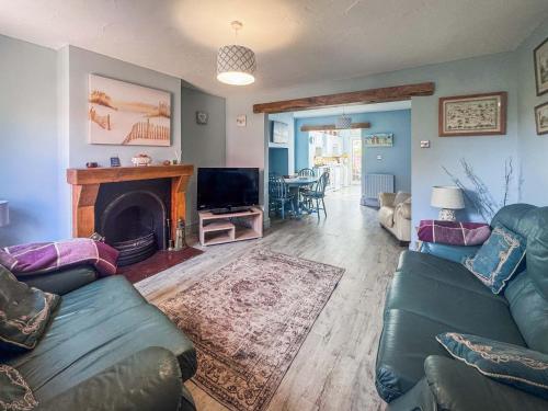 a living room with a couch and a fireplace at Penny Cottage in Heacham