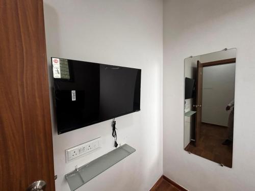 a flat screen tv on the wall of a hotel room at Hotel Dwarka Executive in Nashik