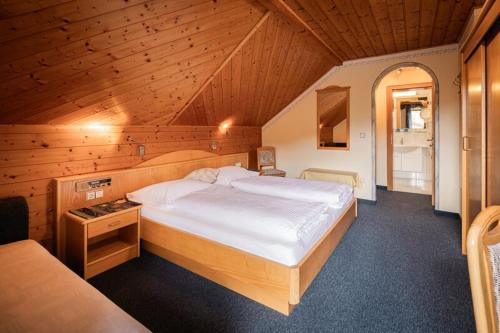 a bedroom with a large bed in a wooden room at Grillhofer - Slow Living Apartments -LUNGAUCard inkludiert in Mauterndorf