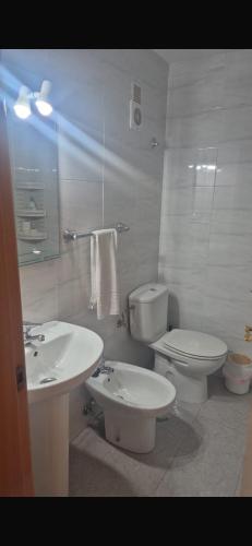 a white bathroom with a toilet and a sink at Beach Palo Malaga in Málaga