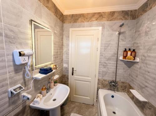 a bathroom with a sink and a toilet and a tub at the LOFT - Elite Residence in Cairo
