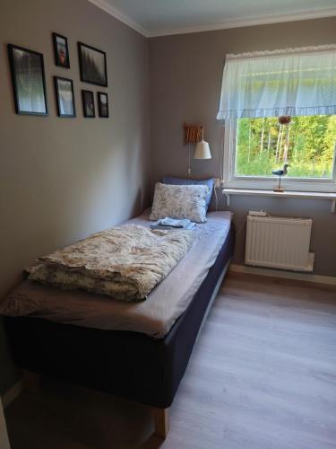 a bed in a bedroom with a window at Stuga vad vatten in Åsarp