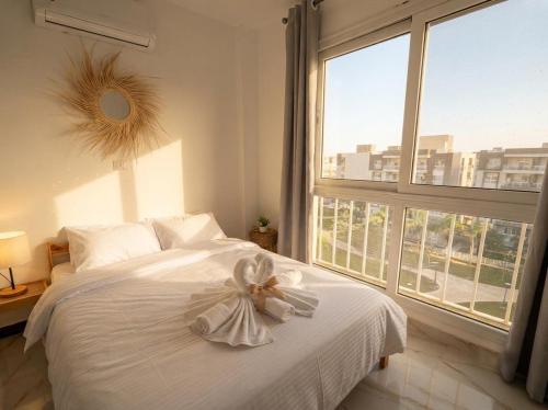 a bedroom with a white bed with a bow on it at the LOFT - Elite Residence in Cairo