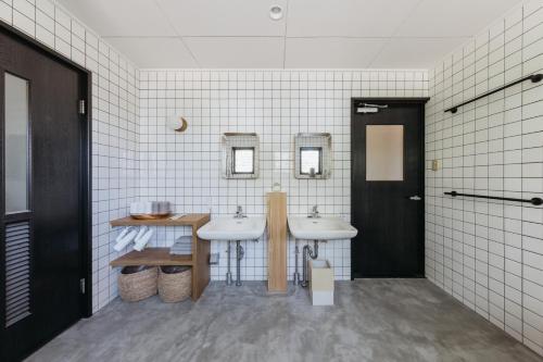 a bathroom with two sinks and two mirrors at o ku in Awaji