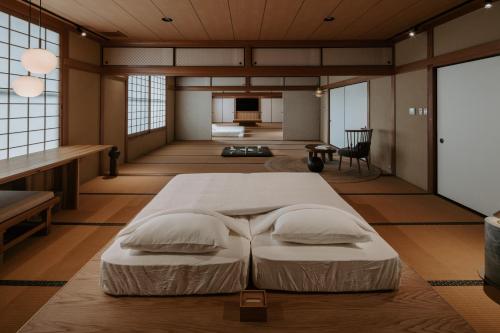 a bedroom with a large bed with two pillows at o ku in Awaji