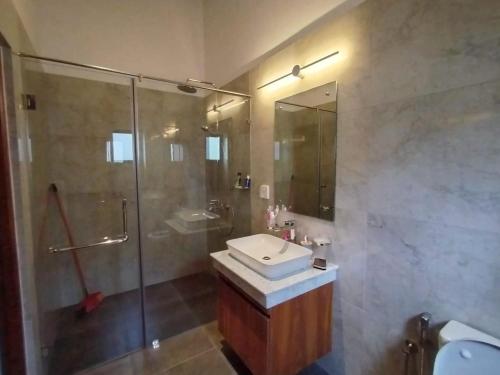 a bathroom with a shower and a sink and a toilet at Villa 80 in Gonapola